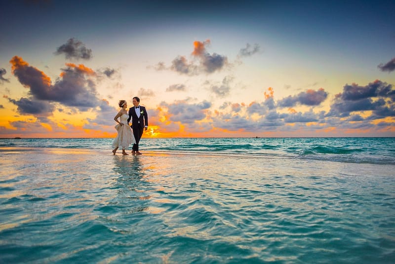 Destination wedding couple walking on the sand