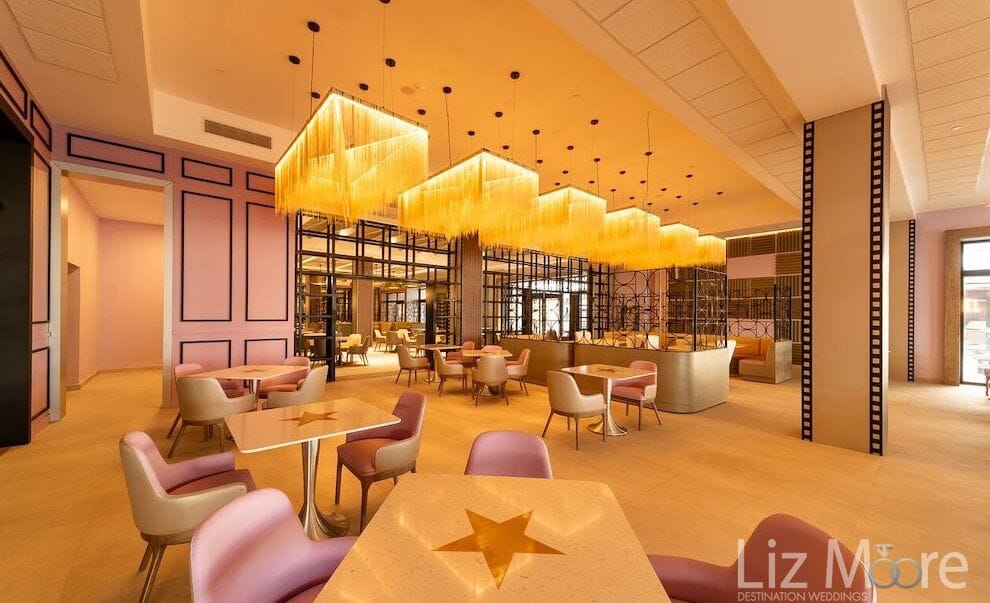 Dining room at planet hollywood beach with yellow chandeliers and pink chairs