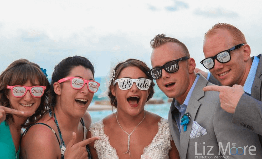 Bride grom and guests with sunglasses on beach at destination wedding