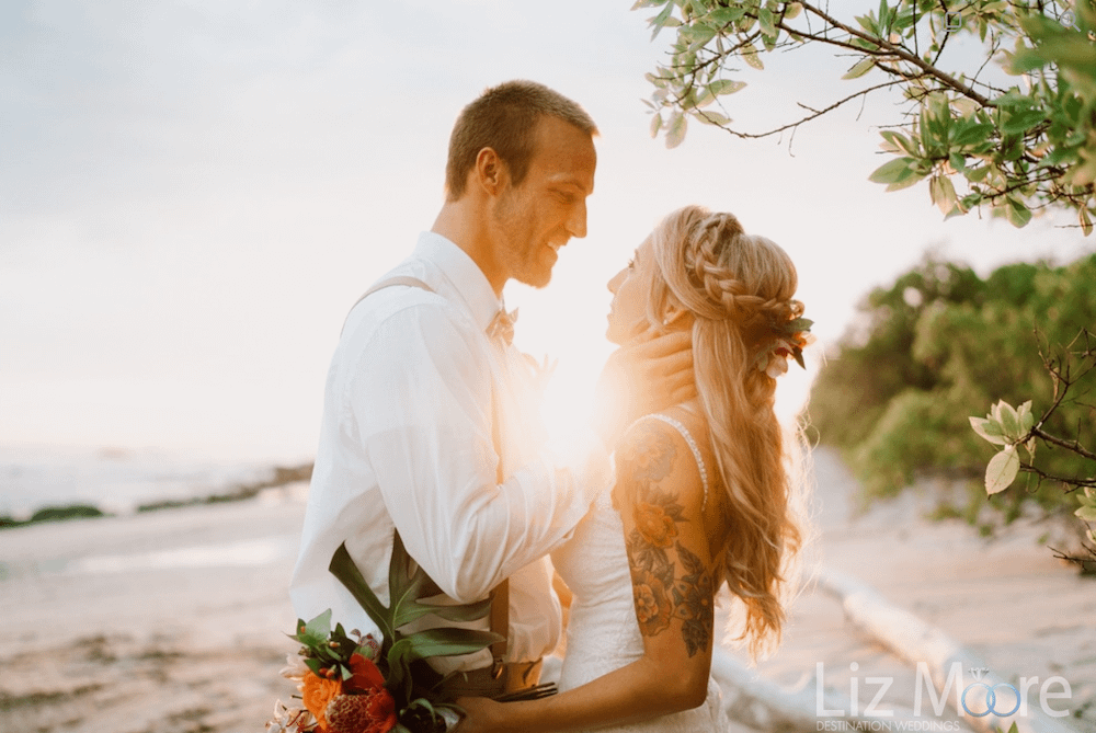 Sunset beach wedding with bride and groom and palm trees and beach
